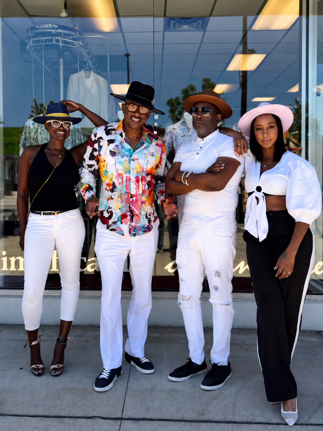 Four clients in Kerry Kouture fedoras outside the boutique storefront